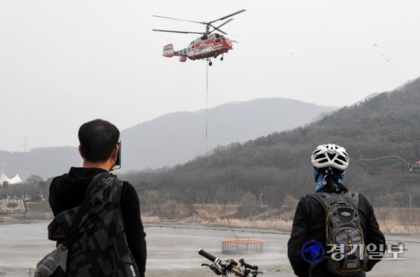 15일 오후 인천시 남동구 인천대공원에서 산림청 소방 헬기가 대형 저수조를 호수로 옮기고 있다. 전국 최초로 사계절 산불진화 헬기 담수용으로 제작한 지름 6m, 높이 1.9m 규모의 스테인리스 원형 그물망 형태의 저수조는 침전물과 결빙을 방지하는 특징을 갖고 있다. 장용준기자