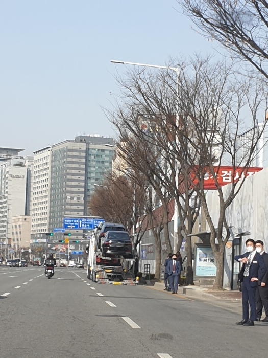 ▲ 안양시의 한 수입차 전시장 직원들이 도로 앞까지 나와 통행 차량들의 차로 변경을 유도하고 있다.(사진=독자 제공)