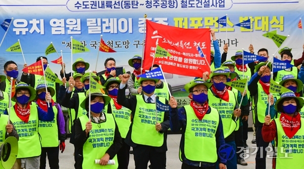 30일 오전 화성시 동탄역에서 수도권내륙선 철도건설사업 유치 염원 릴레이 종주 참가자들이 발대식에 참석해 깃발을 흔들며 퍼포먼스를 하고 있다. 조주현기자