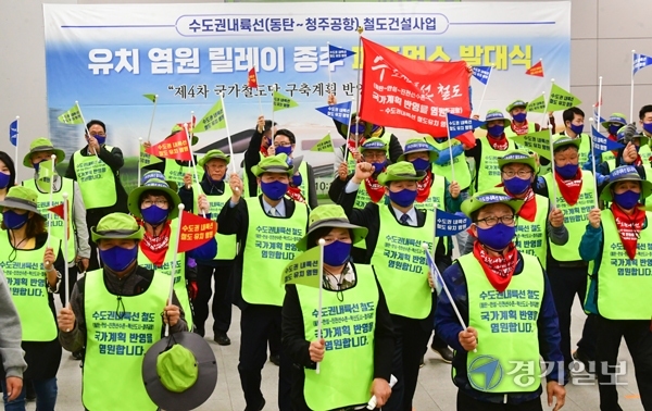 30일 오전 화성시 동탄역에서 수도권내륙선 철도건설사업 유치 염원 릴레이 종주 참가자들이 발대식에 참석해 깃발을 흔들며 퍼포먼스를 하고 있다. 조주현기자