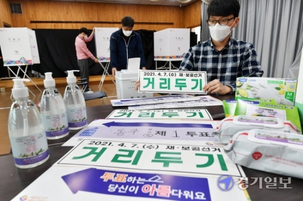 4.7 재보궐선거를 하루 앞둔 6일 오후 구리시 동구동행정복지센터에서 시 선거관리위원회 직원 등이 제1투표소 설치 및 방역용품을 정리하고 있다. 김시범기자