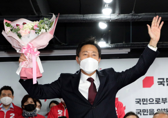 4ㆍ7 재보궐 선거에서 서울시장 당선이 확실해진 국민의힘 오세훈 후보가 8일 자정께 서울 여의도 당사 개표상황실에서 꽃다발을 받고 기뻐하고 있다. 연합뉴스