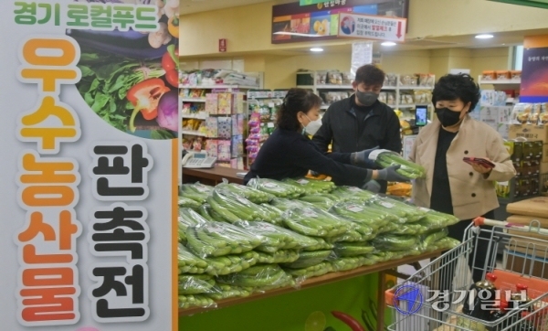 13일 오전 안성시 당왕동 대덕농협하나로마트에서 열린 '경기로컬푸드 판촉전'에서 관계자가 물건을 구매한 시민들에게 지역농산물을 증정하고 있다. 윤원규기자