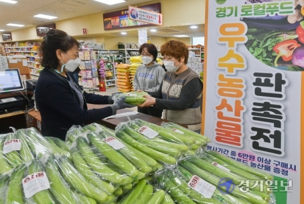 13일 오전 안성시 당왕동 대덕농협하나로마트에서 열린 ‘경기 로컬푸드 우수농산물 판촉전’에서 판매원이 물건을 구매한 소비자들에게 지역농산물을 증정하고 있다. 지역 농가를 돕기위해 열린 이번 농산물 판촉전은 오는 18일까지 진행된다.윤원규기자