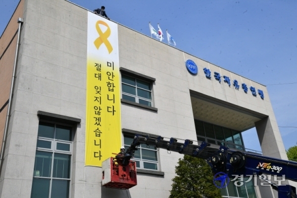 세월호 참사 7주기를 하루 앞둔 15일 오전 한국자유총연맹 수원시지회 건물 외벽에 세월호 희생자를 추모하는 대형 현수막이 설치되고 있다. 김주형 연맹 수원지회장은 