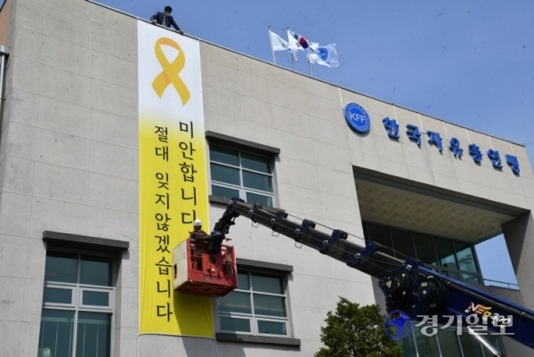 세월호 참사 7주기를 하루 앞둔 15일 오전 한국자유총연맹 수원시지회 건물 외벽에 세월호 희생자를 추모하는 대형 현수막이 설치되고 있다. 김주형 연맹 수원지회장은 