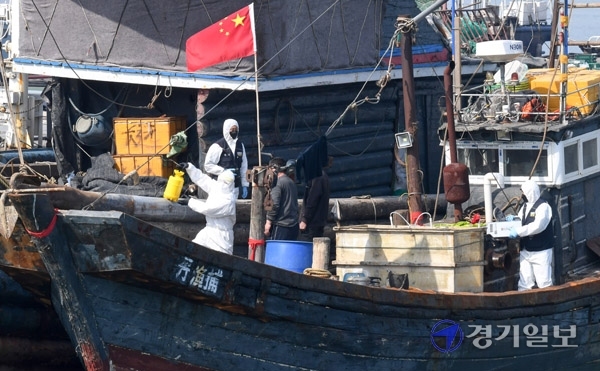 21일 오전 인천 중구 인천해경 전용부두에서 방역 당국 관계자들이 중부해경청 함정이 나포한  불법조업 중국어선을 소독하고 있다. 이 어선은 지난 20일 인천 옹진군 소청도 인근 해상에서 불법조업을 하다가 해경에 나포됐다. 장용준기자