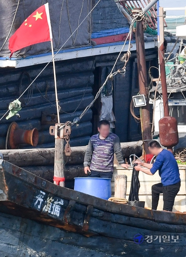 21일 오전 인천 중구 인천해경 전용부두에서 방역 당국 관계자들이 중부해경청 함정이 나포한  불법조업 중국어선을 소독하고 있다. 이 어선은 지난 20일 인천 옹진군 소청도 인근 해상에서 불법조업을 하다가 해경에 나포됐다. 장용준기자