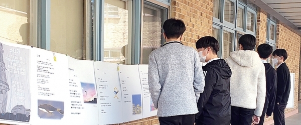 ▲ 반송중학생들이 ‘꽃, 비, 별, 밤, 바다, 가족, 그리고 2014. 4ㆍ16의 기억’을 주제로한 시 전시회에서 시를 감상하고 있는 모습.  반송중학교 제공