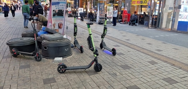 옥정신도시 중심상가 도로변에 방치돼 있는 전동킥보드들. 이종현기자
