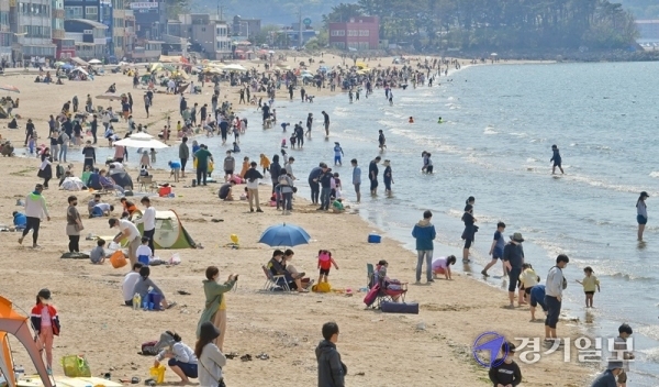 낮기온이 25도 가까이 오른 25일 오후 안산시 대부도 방아머리해수욕장이 물놀이 인파로 붐비고 있다. 화창한 날씨가 계속되면서 도내 유원지, 해수욕장마다 벌써부터 나들이객들이 몰리는 가운데 관광지에 대한 코로나19 예방 대책이 요구되고 있다.   윤원규기자