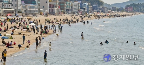 낮기온이 25도 가까이 오른 25일 오후 안산시 대부도 방아머리해수욕장이 물놀이 인파로 붐비고 있다. 화창한 날씨가 계속되면서 도내 유원지, 해수욕장마다 벌써부터 나들이객들이 몰리는 가운데 관광지에 대한 코로나19 예방 대책이 요구되고 있다.   윤원규기자