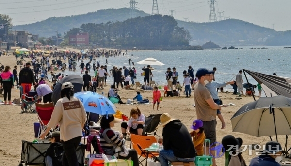 낮기온이 25도 가까이 오른 25일 오후 안산시 대부도 방아머리해수욕장이 물놀이 인파로 붐비고 있다. 화창한 날씨가 계속되면서 도내 유원지, 해수욕장마다 벌써부터 나들이객들이 몰리는 가운데 관광지에 대한 코로나19 예방 대책이 요구되고 있다.   윤원규기자