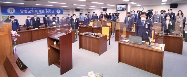 지난 15일 열린 ‘양평군의회 개원 30주년 기념식’에서 의원들이 국민의례를 하고 있다. 양평군의회 제공