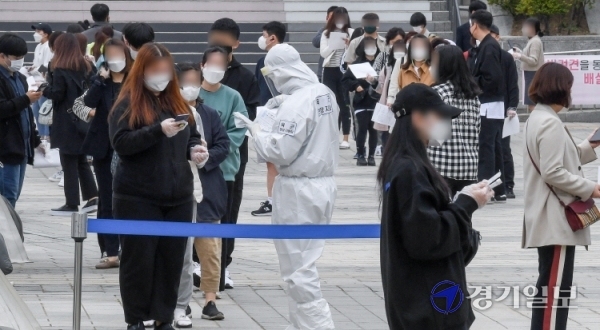 인천 미추홀구 롯데백화점 인천터미널점에서 코로나19 확진 직원들이 잇따라 나온 27일 오전 인천종합문예회관 광장에 설치한 코로나19 남동구 선별 검사소에서  백화점 직원들이 전수검사를 받기 위해 줄을 서 있다. 장용준기자