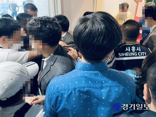 14일 오전 경기도 시흥시의회에서 주민 20여명이 배곧동 분동안 통과에 반대하며 공무원들과 몸싸움을 벌이고 있다. 이날 배곧동 분동안은 본회의 표결 13명 중 8명 찬성, 4명 반대, 1명 기권으로 최종 통과됐다. 김형수기자