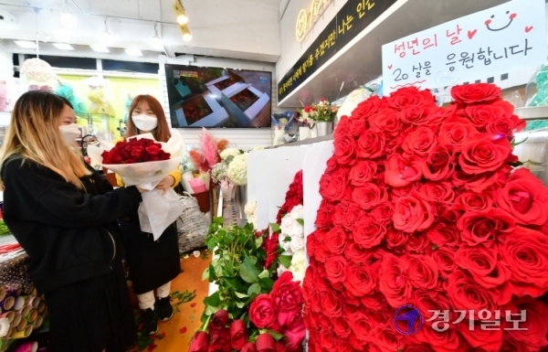 성년의 날을 하루 앞둔 16일 오전 백송이전문점 안양점에서 한 학생이 친구에게 선물할 장미꽃 다발을 구입하고 있다.조주현기자