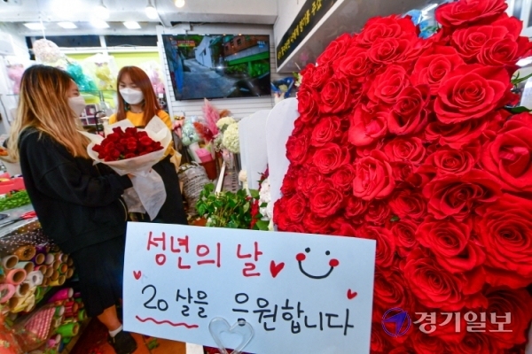 성년의 날을 하루 앞둔 16일 오전 백송이전문점 안양점에서 한 학생이 친구에게 선물할 장미꽃 다발을 구입하고 있다.조주현기자