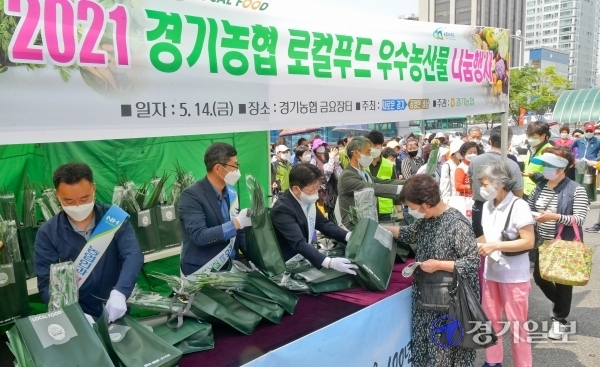 14일 오전 경기농협지역본부 주차장에서 열린 '2021 경기농협 로컬푸드 우수농산물 나눔행사'에서 이해원 경기도 농식품유통과장, 정용왕 농협중앙회 경기지역본부장, 김길수 경기농협영업본부장 등 내빈들이 경기농협 금요장터를 찾은 시민들에게 농산물을 증정하고 있다. 윤원규기자