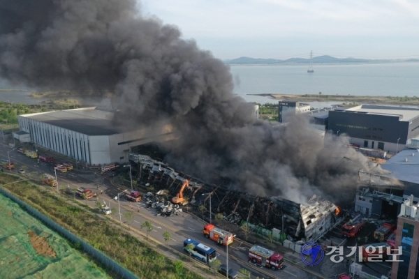 19일 오후 2시12분께 화재가 발생한 시흥시 정왕동 생필품 보관창고에서 시커먼 연기가 하늘로 치솟는 가운데 소방관들이 진화작업을 벌이고 있다. 조주현기자