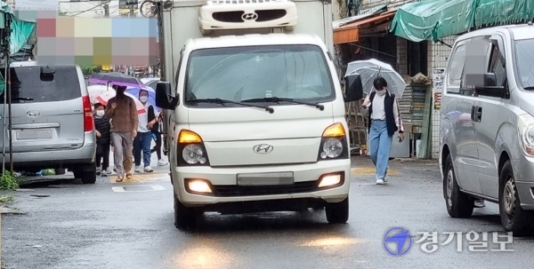 지난 21일 인천 부평구 산곡초등학교 앞 통학로에서 등교하던 아이들이 불법주차 차량과 그 사이를 지나는 트럭 때문에 멈춰섰다 걷기를 반복하고 있다. 강우진기자