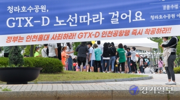 23일 GTX-D 인천시민추진단 주최, '인천공항발 GTX-D 노선 따라 걸어요' 행사가 열린 서구 청라호수공원에서 청라·영종·루원시티 주민들이 줄지어 제4차 국가철도망 구축계획에 인천공항발 GTX-D 노선 반영을 촉구하는 서명을 하고 있다. 장용준기자