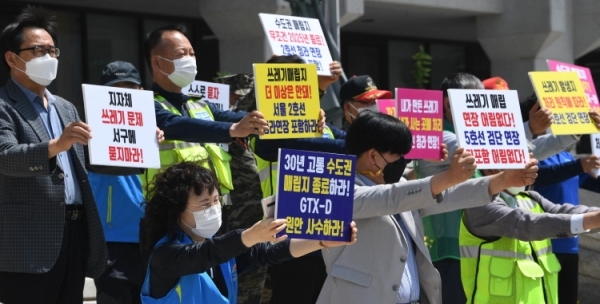 인천 서구지역 단체장 연합회가 24일 오전 인천시청 현관 앞에서 수도권광역급행철도(GTX)-D 노선의 서울 직결과 2025년 수도권매립지 사용 종료를 촉구하는 기자회견을 하고 있다. 장용준기자