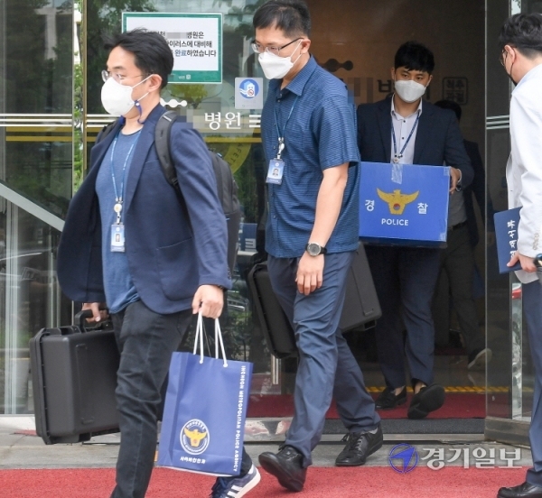 27일 오전  대리수술 의혹을 받고 있는 인천 모 척추 전문병원에서 압수수색을 마친 인천경찰청 광역수사대 경찰들이 압수품을 들고 병원을 나서고 있다. 이 병원은 의사가 아닌 행정직원들이 수술을 하는 등  의료법 위반 혐의를 받고 있다. 장용준기자