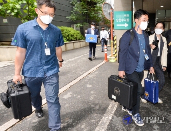 27일 오전  대리수술 의혹을 받고 있는 인천 모 척추 전문병원에서 압수수색을 마친 인천경찰청 광역수사대 경찰들이 압수품을 들고 병원을 나서고 있다. 이 병원은 의사가 아닌 행정직원들이 수술을 하는 등  의료법 위반 혐의를 받고 있다. 장용준기자