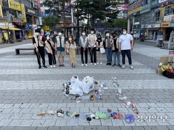 수원YMCA 관계자와 대학생 등이 수거한 쓰레기로 ‘환경의날’ 글자 중 ‘의’자를 만들고 기념사진을 촬영하고 있다. 사진=수원YMCA 제공