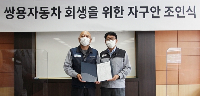 정용원 쌍용차 관리인(오른쪽)과 정일권 노조위원장이 합의안에 서명한 후 기념촬영을 하고 있다. 쌍용차 제공.
