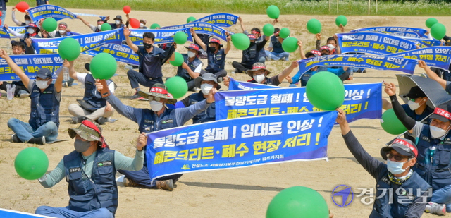 건설노조 서울경기북부지부 건설기계지부 관계자들이 21일 오후 과천정부청사 앞에서 열린  ‘펌프카 노동자 총파업 투쟁 선포 결의대회’에서 현수막을 들고 구호를 외치고 있다.  윤원규기자