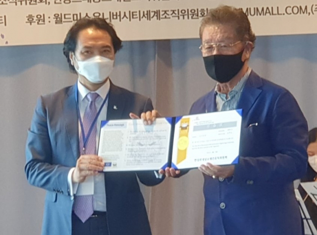 제33회 월드미스유니버시티(WMU) 한국대회 오리엔테이션서 한강르네상스조직위원회 강성모 위원장(왼쪽)이 위촉장을 전달하고 있다.조직위원회 제공