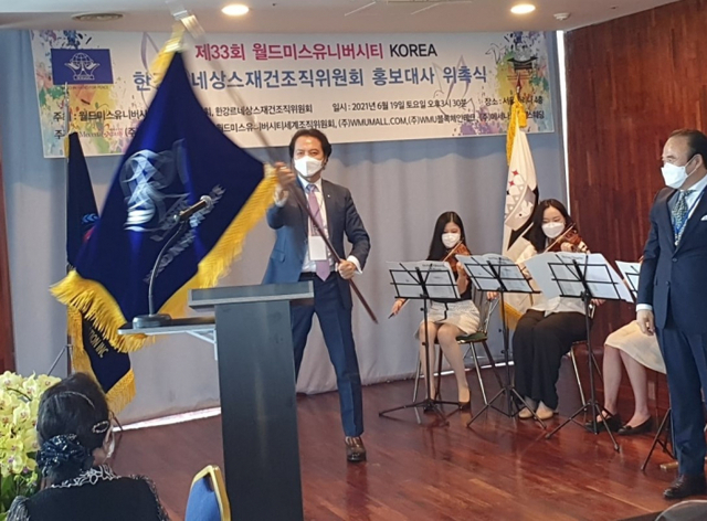 제33회 월드미스유니버시티(WMU) 한국대회 오르엔테이션서 한강르네상스조직위원회 강성모 위원장이 대회기를 흔들고 있다.대회 조직위원회 제공