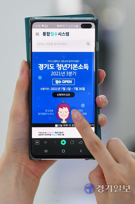 '경기도 청년기본소득' 3분기 접수가 시작된 1일 오전 수원시내 한 사무실에서 청년이 휴대폰을 통해 지급 신청을 하고 있다. 지급대상은 경기지역 3년 이상 계속 거주 또는 10년 이상 합산거주 만 24세 청년이며 온라인 또는 모바일로 신청할 수 있다. 김시범기자