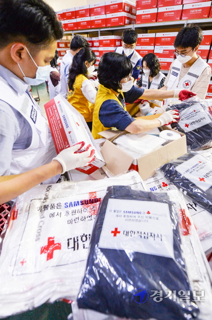 8일 오전 인천 연수구 대한적십자사인천지사 구호창고에서 봉사원들이 장마철 재난대비용 긴급 구호물품 200세트를 만들고 있다. 장용준기자
