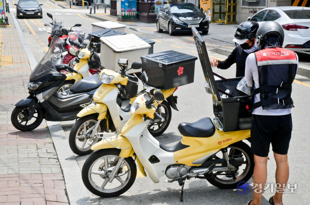 13일 오전 수원시 인계동에서 배달 음식점에서 오토바이 라이더들이 배달을 하고 있다. 코로나19로 배달업계가 성황인 가운데 이날부터 전국 배달라이더 2만 3000여명을 대상으로 화이자 백신 접종이 시작됐다. 윤원규기자