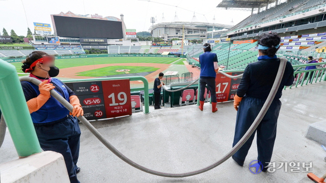 코로나19 여파로 KBO 리그 전반기 잔여 경기가 전격 중단한 13일 전광판이 꺼진 인천 미추홀구 인천SSG 랜더스필드에서 관계자들이 물청소를 하고 있다.  KBO는 이날부터 18일까지 편성한 KBO 리그 전반기 잔여 경기(30경기)와 21일까지의 퓨처스리그 경기(35경기)를 추후 편성해 특별한 사유가 없는 한 시즌 720경기를 정상 개최할 예정이다. 장용준기자