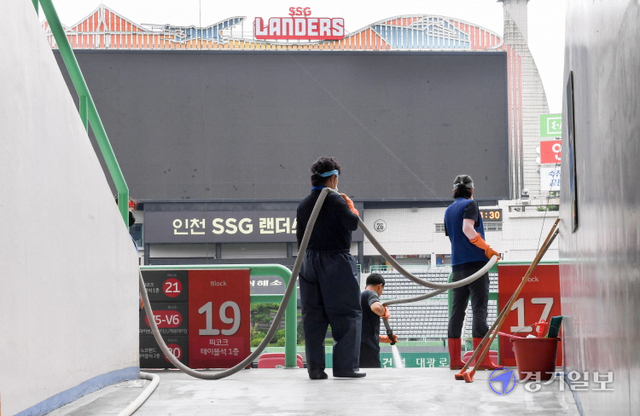 코로나19 여파로 KBO 리그 전반기 잔여 경기가 전격 중단한 13일 전광판이 꺼진 인천 미추홀구 인천SSG 랜더스필드에서 관계자들이 물청소를 하고 있다.  KBO는 이날부터 18일까지 편성한 KBO 리그 전반기 잔여 경기(30경기)와 21일까지의 퓨처스리그 경기(35경기)를 추후 편성해 특별한 사유가 없는 한 시즌 720경기를 정상 개최할 예정이다. 장용준기자