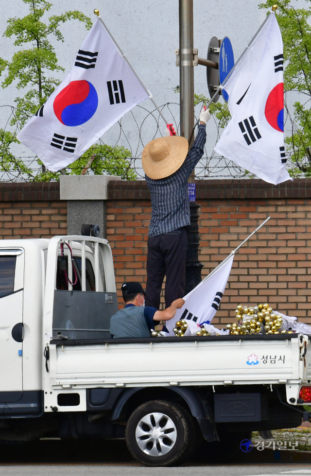 제헌절을 하루 앞둔 16일 오후 성남시 수정구 심곡동 일대에서 시 관계자가 도로변에 태극기를 게양하고 있다.조주현기자