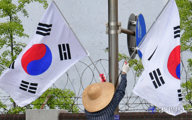 제헌절을 하루 앞둔 16일 오후 성남시 수정구 심곡동 일대에서 시 관계자가 도로변에 태극기를 게양하고 있다.조주현기자