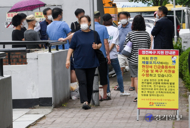19일 폭염속에서  이틀째  정전사태로 불편을 겪고 있는 인천 미추홀구 용현동의 한 아파트 주민들이  복구 작업중인 수전실 앞에서 모여 분통을 터뜨리고 있다. 장용준기자