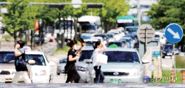 경기지역에 폭염특보가 내려진 20일 오후 수원 시내 한 도로 아스팔트 위로 뜨거운 열기를 머금은 아지랑이가 피어오르고 있다. 김시범기자