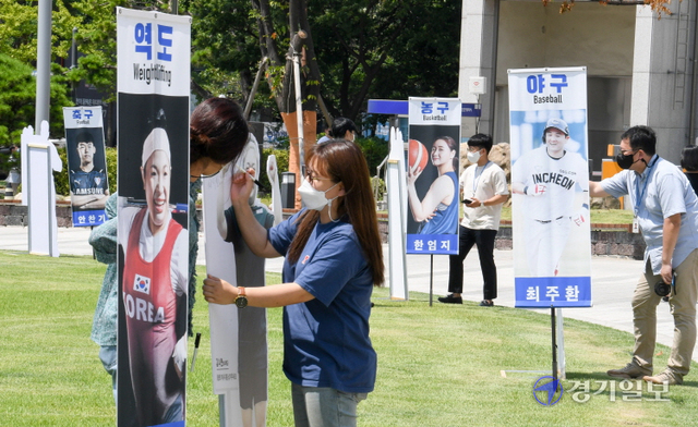 제32회 일본 도쿄올림픽 개막을 하루 앞둔 22일 오전 인천시청 애뜰광장에서 시민들이 인천 연고 선수들의 배너와 함께 세워진 입간판에 응원 메시지를 적고 있다. 장용준기자
