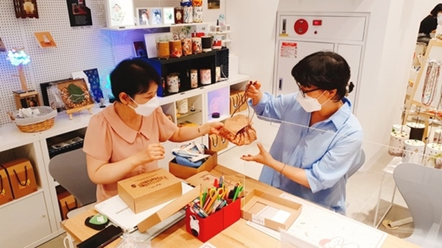 ▲아티즈굿즈 김경아 대표와 신경순 작가가 제주도 설문대할망과 오백장군 스토리를 담은 새로운 굿즈 ‘봇짐 파우치’에 대한 협업을 진행하고 있다. 