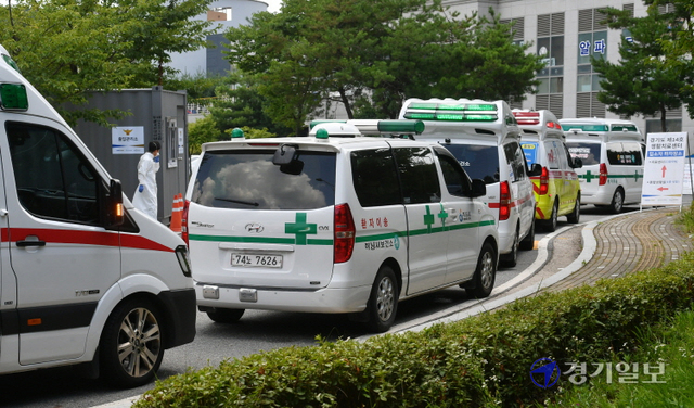 코로나19 신규 확진자가 1천896명 발생, 사상 최다를 기록한 28일 오후 수원시 경기대학교 기숙사에 마련된 생활치료센터 입구에서 확진자를 실은 응급차량들이 길게 줄지어 선 채 입소를 기다리고 있다. 김시범기자