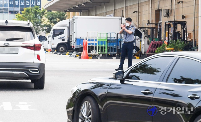 31일 임시 휴업에 들어간 인천 남동구 남촌농산물도매시장 과일동 앞에서 관계자가 손짓으로 휴업을 알리고 있다. 폭염과 코로나19의 이중고 속에 ㈜대인농산을 비롯한 4개 도매시장법인 신청에 따라 결정한 이번 임시 휴업은 시장 내 채소동과 과일동에서 정기 휴업일인 8월1일까지 이틀동안 이뤄졌다. 장용준기자