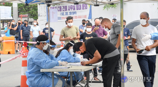 지난 2월에 이어 코로나19 집단감염 재발생으로 검체검사 행정명령이 내려진 인천 연수구 옥련동 인천중고차수출단지 정문에서 2일 오후 길게 늘어선 외국인 종사자들을 비롯한 방문자들이 검사순서를 기다리고 있다. 장용준기자