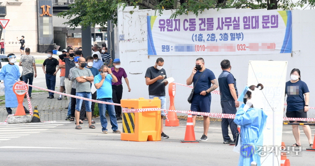 지난 2월에 이어 코로나19 집단감염 재발생으로 검체검사 행정명령이 내려진 인천 연수구 옥련동 인천중고차수출단지 정문에서 2일 오후 길게 늘어선 외국인 종사자들을 비롯한 방문자들이 검사순서를 기다리고 있다. 장용준기자