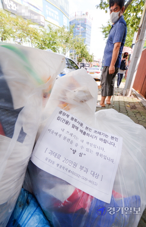 4일 오후 인천 부평구 경인국철 동암역 인근 거리에 쌓여있는 무단 투기 쓰레기 봉투에 '양심' 안내문이  붙어 있다. 장용준기자